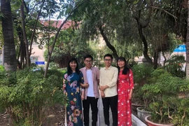 Hai anh em sinh đôi Bùi Quốc Bảo và Bùi Hữu Bảo cùng giáo viên trường THPT Lý Tự Trọng, thành phố Nha Trang. (Ảnh: TTXVN phát)