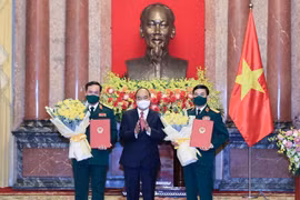 Chủ tịch nước Nguyễn Xuân Phúc trao Quyết định thăng quân hàm cho Bộ trưởng Bộ Quốc phòng Phan Văn Giang và Thứ trưởng Bộ Quốc phòng Vũ Hải Sản. (Ảnh: Thống Nhất/TTXVN)