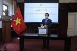 Đại sứ đặc mệnh toàn quyền Việt Nam tại LB Nga Đặng Minh Khôi quyên góp ủng hộ Quỹ vaccine phòng Covid-19. (Ảnh: Trần Hiếu/TTXVN)