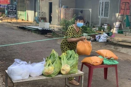 Người dân tại vực chợ Đắk Ơ (xã Đắk Ơ, huyện Bù Gia Mập, tỉnh Bình Phước) nhận thực phẩm miễn phí. (Ảnh: TTXVN phát)