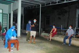 Lực lượng y tế xét nghiệm người dân, công nhân khu vực phát hiện ca dương tính tại Bình Phước. (Ảnh: K GỬIH/TTXVN)