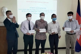 Đại sứ Vũ Quang Minh (bên trái) bàn giao kinh phí các cơ quan đại diện tại Campuchia và Hội Khmer-Việt Nam tại Campuchia. (Ảnh: Ngọc Long/TTXVN)