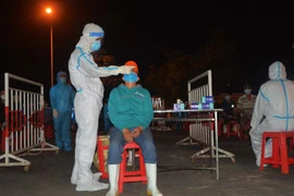 Nhân viên y tế lấy mẫu xét nghiệm cho người dân Cảng cá Thọ Quang vào tháng 5. (Ảnh: Văn Dũng/TTXVN)