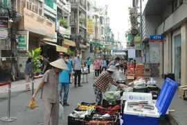 Người dân mua hàng hóa thiết yếu tại một Phiên chợ lưu động được tổ chức tại khu phố 3, phường 2, Quận 3, Thành phố Hồ Chí Minh. (Ảnh: Quang Châu/TTXVN)