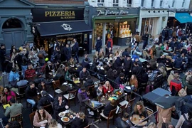 Thực khách dùng bữa tại một nhà hàng ở London, Anh. (Ảnh: AFP/TTXVN)