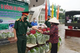 Đại diện Sư đoàn 302 trao sản phẩm từ “Siêu thị 0 đồng di động” cho người dân xã Châu Pha. (Ảnh: Huỳnh Ngọc Sơn/TTXVN)