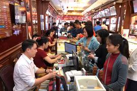 Khách hàng giao dịch vàng khu vực Hà Nội. (Ảnh: Đức Duy/Vietnam+)