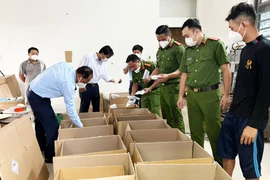 Lực lượng chức năng kiểm tra cơ sở sản xuất thuốc bảo vệ thực vật nghi giả nhãn hiệu. (Ảnh: PV/Vietnam+)