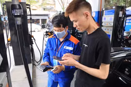 Nhân viên Petrolimex in hóa đơn mua xăng cho khách hàng. (Ảnh: Đức Duy/Vietnam+)