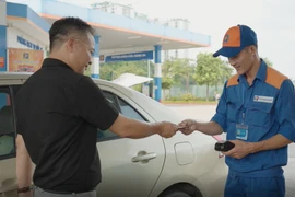 Nhân viên Petrolimex xuất hóa đơn bán lẻ xăng dầu cho khách hàng. (Ảnh: Đức Duy/Vietnam+)