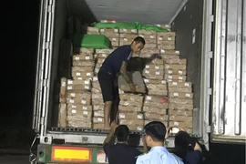 Lực lượng chức năng tỉnh Quảng Ninh kiểm tra xe ôtô chở hàng chục tấn chân gà đông lạnh không rõ nguồn gốc. (Ảnh: PV/Vietnam+)