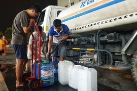 Người dân Khu Đô thị Thanh Hà lấy nước từ xe chở nước sạch. (Ảnh: Hoàng Hiếu/TTXVN)