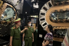 Lực lượng chức năng tiến hành kiểm tra một cơ sở karaoke tại quận Hoàn Kiếm. (Ảnh TTXVN)