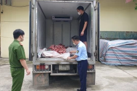 Lực lượng chức năng kiểm tra xe ôtô chở xương và lòng lợn không rõ nguồn gốc. (Ảnh: PV/Vietnam+)