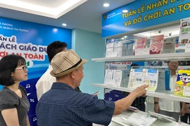 Hướng dẫn người tiêu dùng phân biệt hàng giả tại phòng trưng bày của Tổng cục Quản lý Thị trường. (Ảnh: Đức Duy/Vietnam+) 