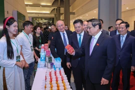 Thủ tướng Phạm Minh Chính thăm gian hàng của Công ty TH bên lề Lễ công bố sản phẩm đạt thương hiệu quốc gia, lần thứ 9. (Ảnh: PV/Vietnam+)