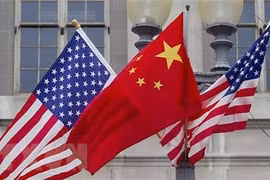 Quốc kỳ Trung Quốc (giữa) và quốc kỳ Mỹ. (Ảnh: Getty Images/TTXVN)