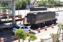 Xe ôtô con bám sát xe phía trước để vượt trạm, khi thanh barie chưa kịp đóng lại. (Ảnh: Nguyên Lý/TTXVN)