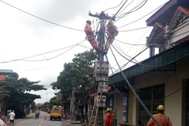 Điện lực Thanh Hà huy động nhân lực, trang thiết bị nhanh chóng có mặt tại hiện trường khắc phục sự cố. (Ảnh: Mạnh Tú/TTXVN)
