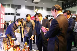 Lãnh đạo Bộ Công thương hai nước và các đại biểu tham quan một số sản phẩm tại hội chợ. (Ảnh: Xuân Tú/TTXVN)