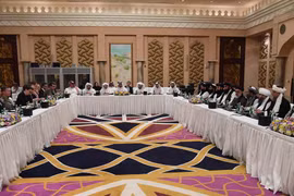 Phái đoàn Mỹ (trái) và phái đoàn Taliban (phải) tại vòng đàm phán hòa bình ở Doha, Qatar ngày 26/2. (Ảnh: AFP/TTXVN)