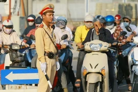 Cảnh sát giao thông và người tham gia giao thông dưới cái nắng nóng lên tới 40 độ C ở Hà Nội. (Ảnh: Doãn Tấn/TTXVN)