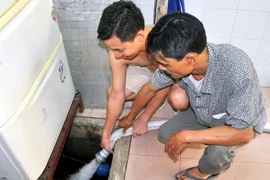 Đưa nước sạch trở lại với người dân. (Ảnh: Nguyễn Hoàng/TTXVN)