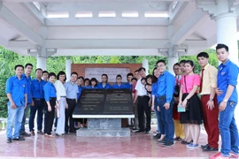 Đoàn hành trình "Về nguồn" chụp ảnh kỷ niệm tại khu nhà bia lưu niệm nơi làm việc của Việt Nam Thông tấn xã ở An toàn khu Sơn Dương, Tuyên Quang. (Ảnh: Minh Sơn/Vietnam+)