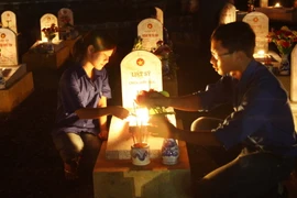 Thắp nến tri ân các liệt sỹ tại Nghĩa trang Liệt sỹ Quốc gia Đường 9. (Ảnh: Hồ Cầu/TTXVN)