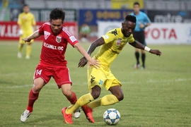 Pha tranh bóng giữa tiền đao Samson (phải-Hà Nội T&T) với Tấn Tài (trái-Becamex Bình Dương). (Ảnh: Quốc Khánh/TTXVN)