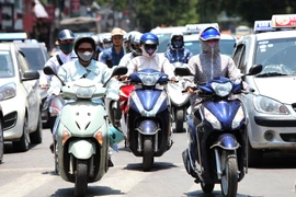 Kín mít từ đầu tới chân là phương pháp chống lại cái nắng nóng của người tham gia giao thông trong những ngày này. (Ảnh: Trọng Đạt/TTXVN)