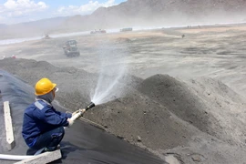 Tưới nước bãi xỉ, hạn chế tối đa tình trạng bụi xỉ than bay vào khu vực dân cư. (Ảnh: Nguyễn Thanh/TTXVN)
