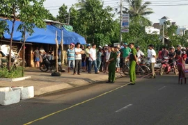 Lực lượng chức năng bảo vệ hiện trường nơi xảy ra vụ án mạng. (Ảnh: Đậu Tất Thành/TTXVN)