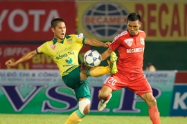 Trận đấu giữa Becamex Bình Dương (áo đỏ) và đội Đồng Tháp (áo vàng) trong khuôn khổ V-League. (Ảnh: Quang Nhựt/TTXVN)