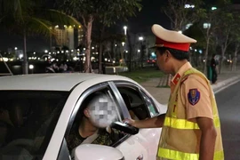 Cảnh sát Giao thông kiểm tra nồng độ cồn đối với người điều khiển xe ôtô. (Ảnh: Xuân Triệu/TTXVN)