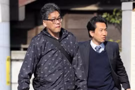 Shibuya Yasumasa (trái) được áp giải lên xe cảnh sát. (Nguồn: Asahi Shimbun)