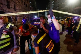 Sơ cứu người dân (thứ hai, phải) bị thương trong vụ khu nghỉ dưỡng Resort World Manila ở Manila bị tấn công ngày 2/6. (Nguồn: EPA/TTXVN)