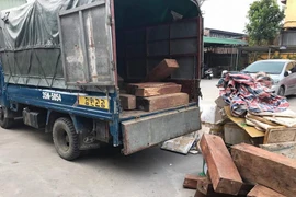 Xe vận chuyển chở gỗ hương lậu tại cơ quan công an. (Ảnh: TTXVN)