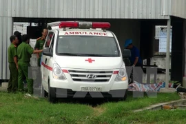 Lực lượng chức năng đưa thi thể nạn nhân ra khỏi hiện trường. (Ảnh: Xuân Triệu/TTXVN)