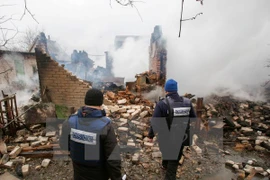 Các quan sát viên OSCE kiểm tra một tòa nhà bị phá hủy sau vụ nã pháo tại Avdiivka ngày 25/2. (Nguồn: EPA/TTXVN)