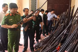 Các lực lượng chức năng kiểm tra số súng săn do đồng bào giao nộp. (Ảnh: Trịnh Duy Hưng/TTXVN)