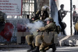 Binh sỹ Israel bắn đạn cao su và hơi cay vào người biểu tình bạo động Palestine ở thành phố Bethlehem, Khu Bờ Tây ngày 18/12/2015. (Nguồn: AFP/TTXVN)