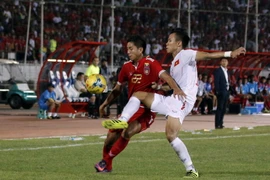 Hậu vệ Quế Ngọc Hải (phải) nỗ lực phá bóng của cầu thủ Myanmar Than Paing trong trận đấu. (Nguồn: EPA/TTXVN)