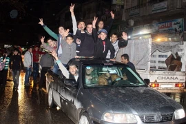 Người dân Syria vui mừng sau khi thành phố Aleppo được giải phóng ngày 12/12. (Nguồn: EPA/TTXVN)