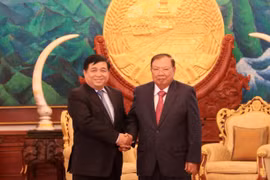 Tổng Bí thư, Chủ tịch nước Lào Bounnhang Volachith (phải) và Bộ trưởng Bộ Kế hoạch và Đầu tư Việt Nam Nguyễn Trí Dũng. (Ảnh: Phạm Kiên/Vietnam+) 