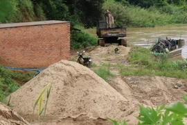 Cát khai thác dưới sông lên được tập kết ngay trên bên bờ chờ vận chuyển đi tiêu thụ. (Ảnh: Nguyễn Dũng/TTXVN)