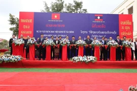 Quan khách hai nước cắt băng khánh thành giai đoạn 3 dự án Học viện Kinh tế-Tài chính Dongkhamxang. (Ảnh: Phạm Kiên/TTXVN)