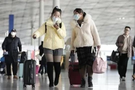 Hành khách tại sân bay ở Bắc Kinh, Trung Quốc. (Ảnh: Kyodo/TTXVN)