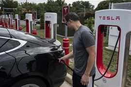 Người dân sạc điện cho ôtô tại một trạm sạc của Tesla ở Arlington, Virginia, Mỹ. (Ảnh: AFP/TTXVN)
