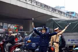 Lực lượng Thanh tra giao thông, cảnh sát giao thông hướng dẫn các phương tiện đi theo đúng tuyến đường. (Ảnh: Huy Hùng/TTXVN)